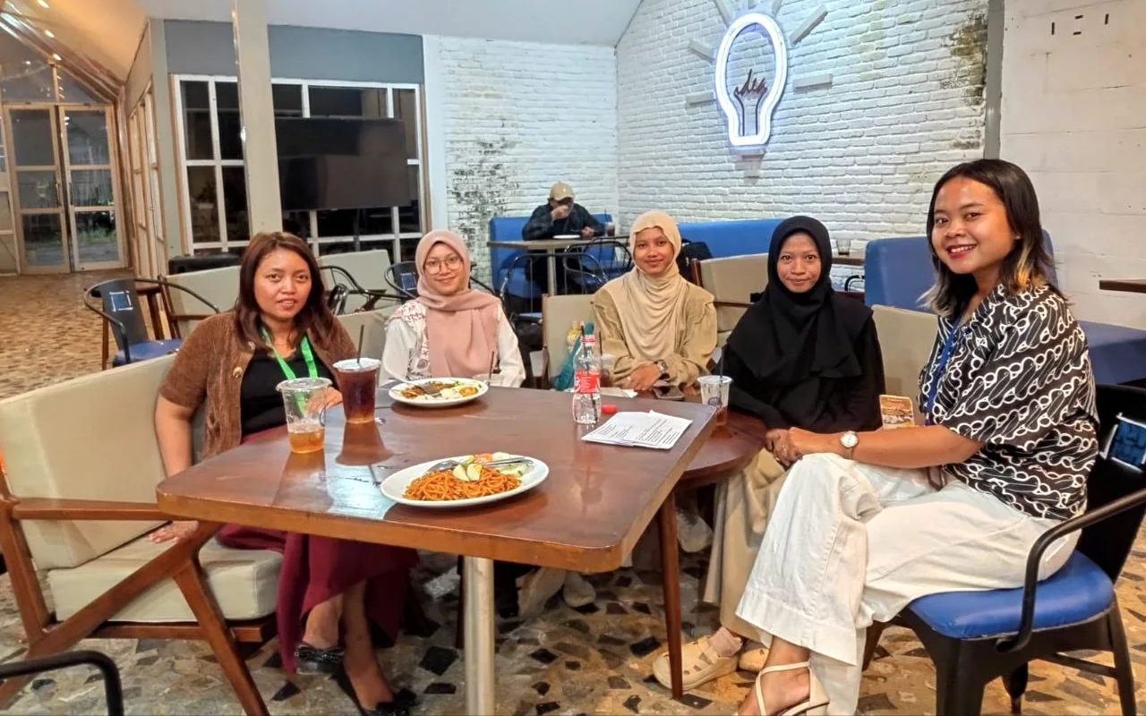 Peserta berkumpul dan berbincang di meja kafe.