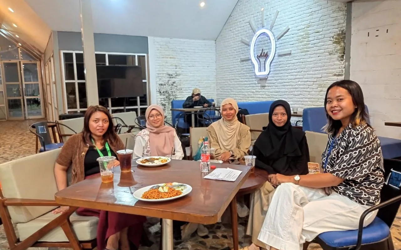 Orang-orang duduk bersama dalam ruang komunitas.