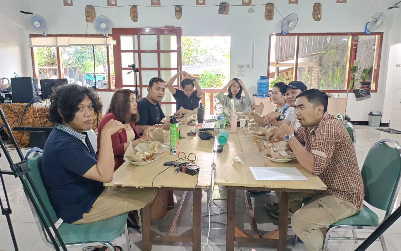 Sekelompok orang berdiskusi di meja komunitas.