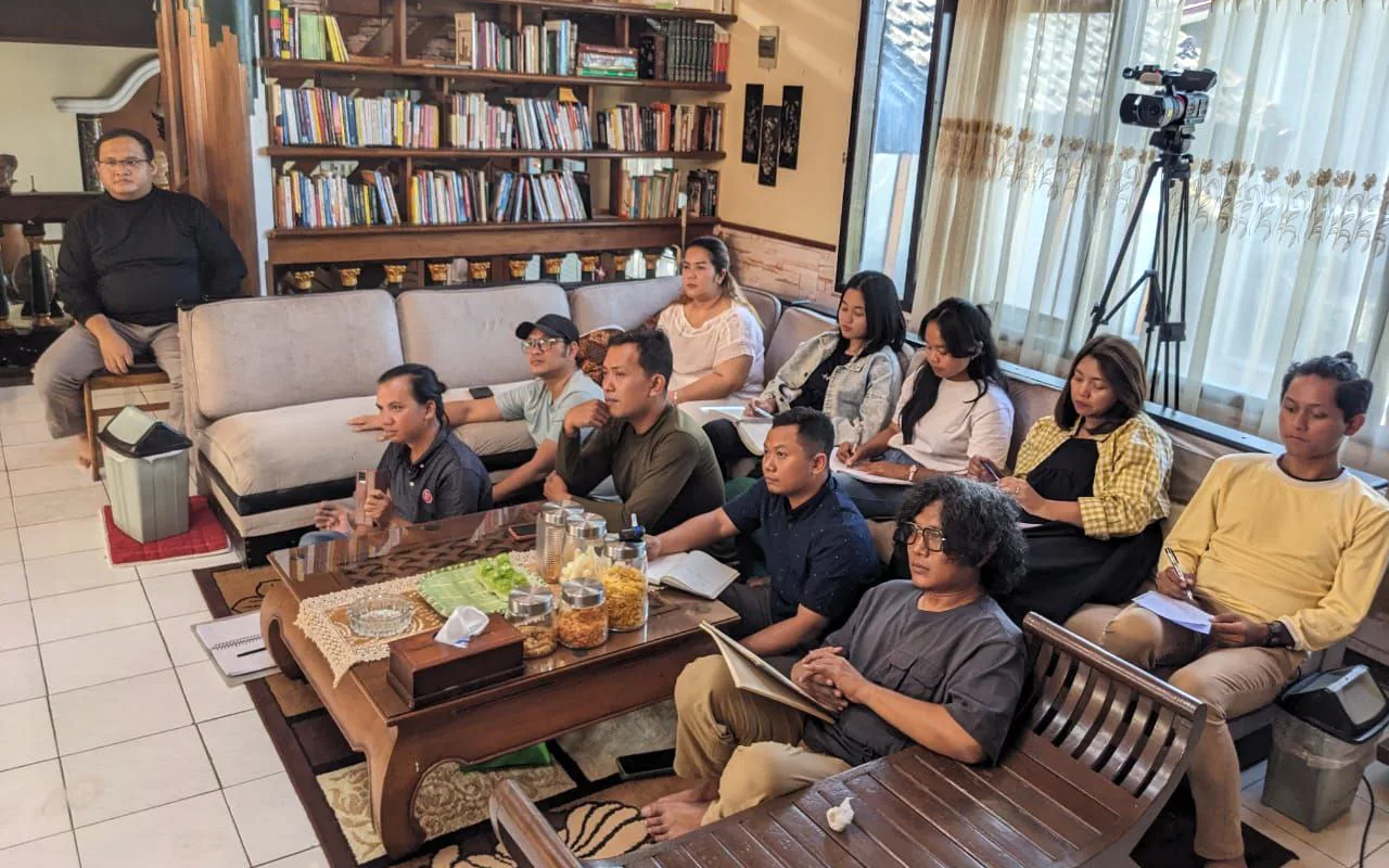 Orang-orang menyimak pembahasan dalam kegiatan komunitas.