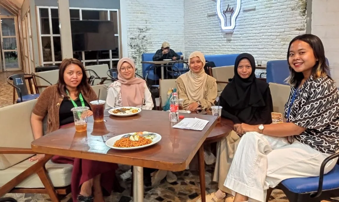 Beberapa peserta duduk bersama di meja dan berdiskusi.