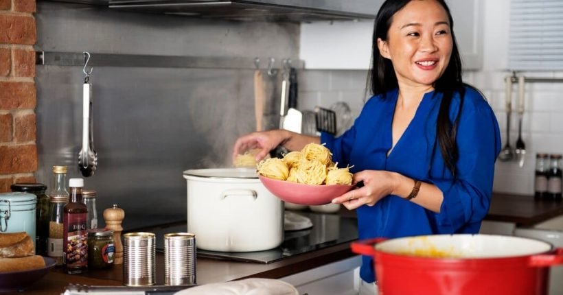 asian-woman-cooking-pasta-kitchen_53876-14943