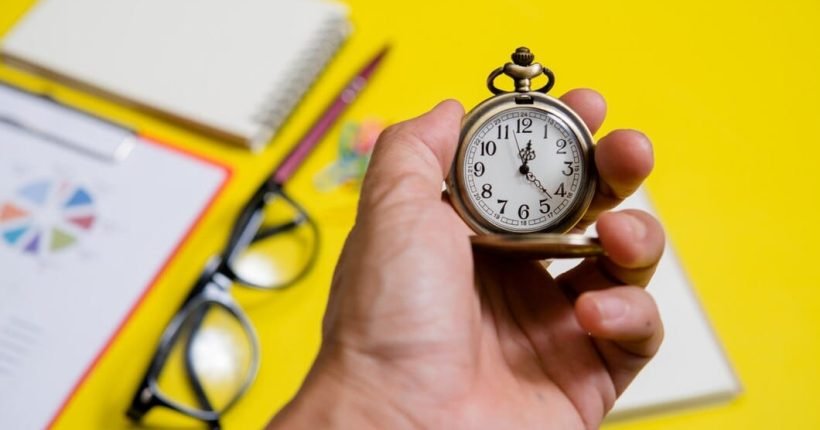 close-up-hand-holding-clock_1150-7673