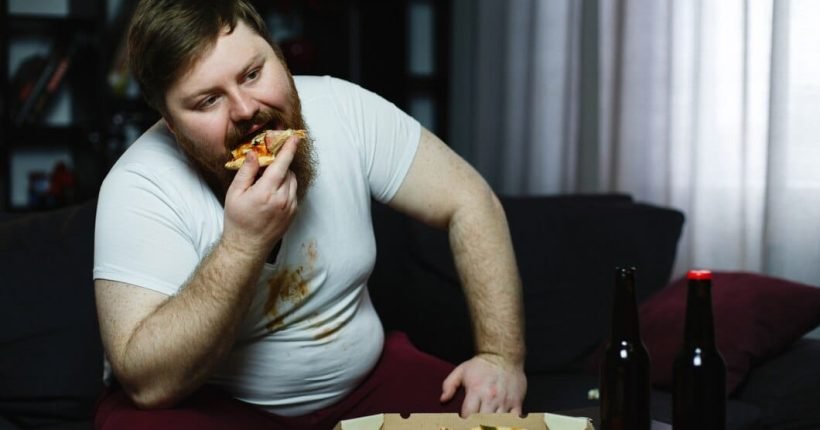 ugly-fat-man-eats-pizza-sitting-sofa_8353-5503
