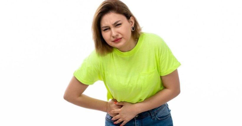 front-view-young-attractive-lady-green-shirt-blue-jeans-suffering-from-stomachache-white_140725-18534
